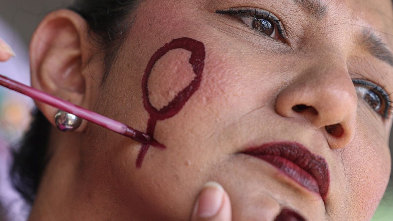 Mulher negra segurando placa de campanha, símbolo de violência política