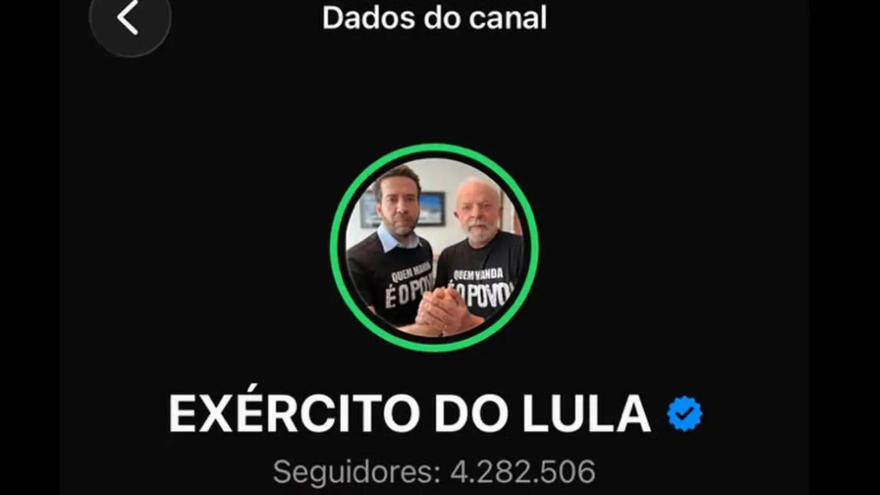 Deputado André Janones ao lado de tela mostrando canal Exército do Lula no WhatsApp