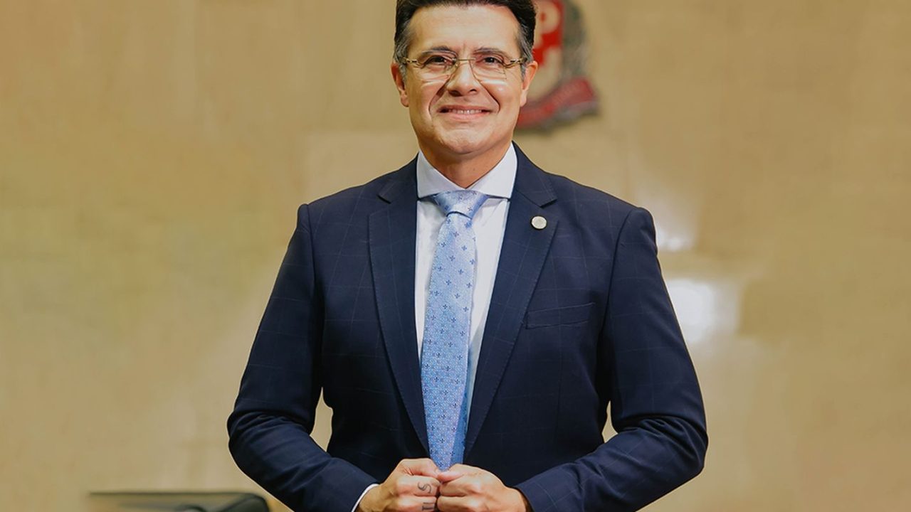 Deputado Marcelo Aguiar sendo escoltado pela polícia em frente a um bar na Vila Nova Conceição