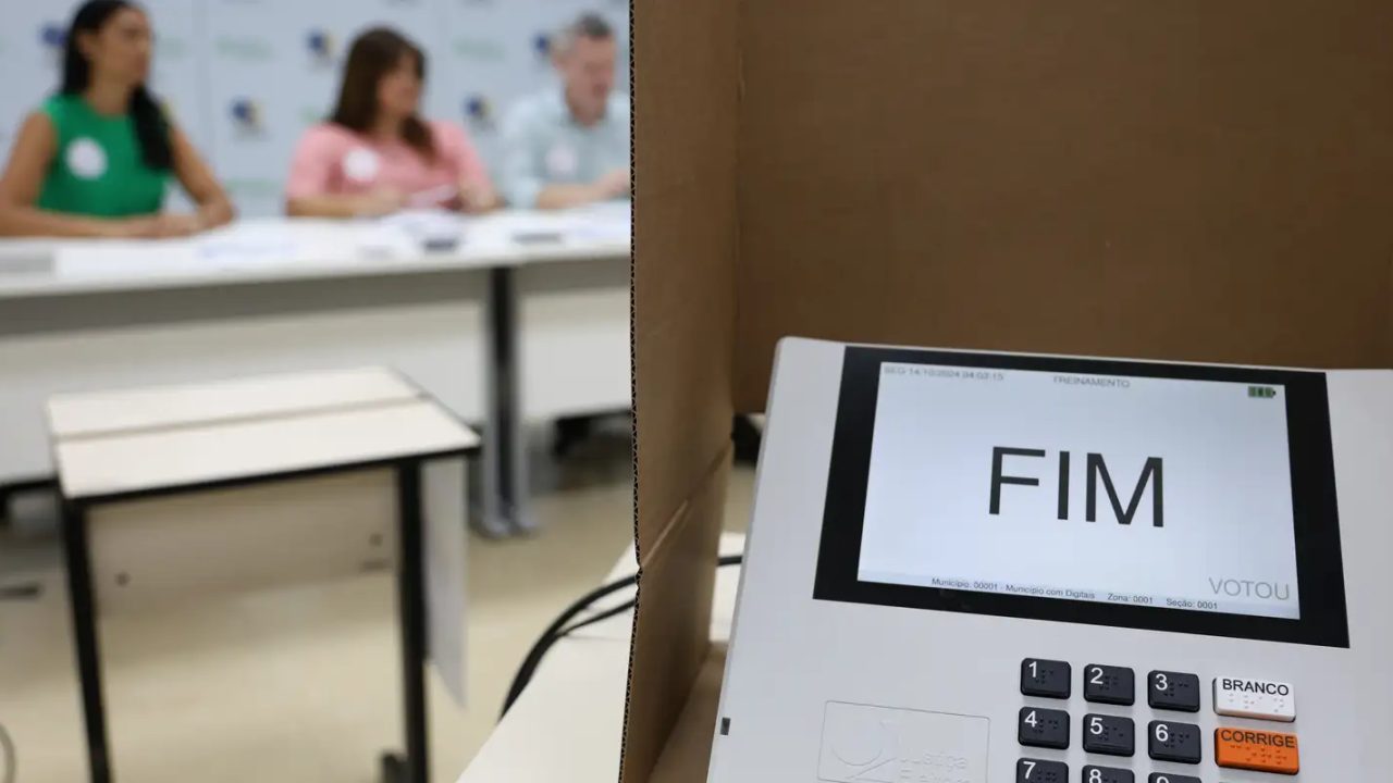 Eleitores idosos e com deficiência acessando a urna eletrônica em local de votação adaptado