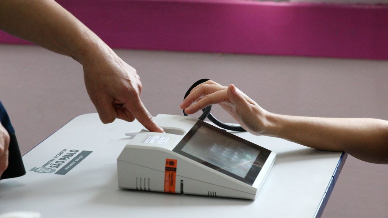 Eleitor apresentando documento de identidade para votar sem biometria