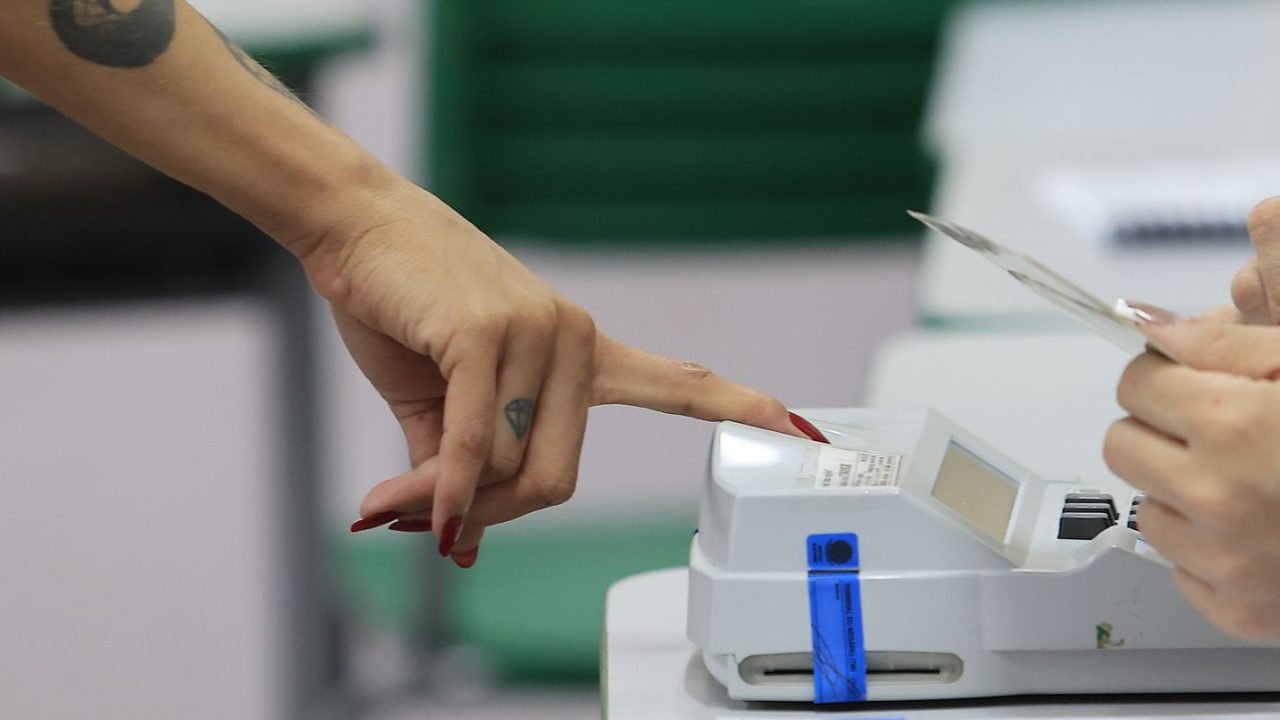Eleitores entrando nas urnas em um dia chuvoso no Rio de Janeiro