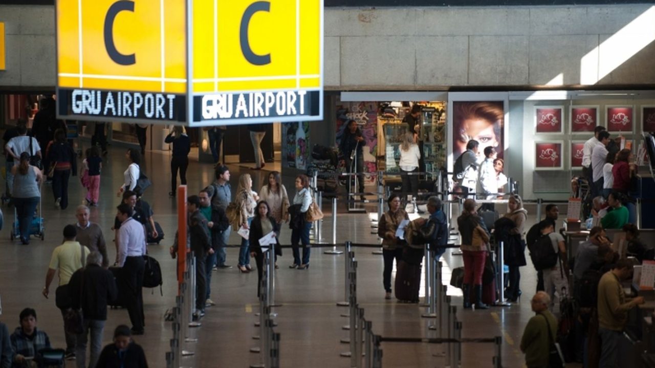 Terminal do Aeroporto de Guarulhos com passageiros circulando