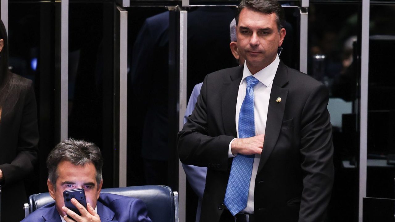 Flávio Bolsonaro segurando carta em ambiente do Senado