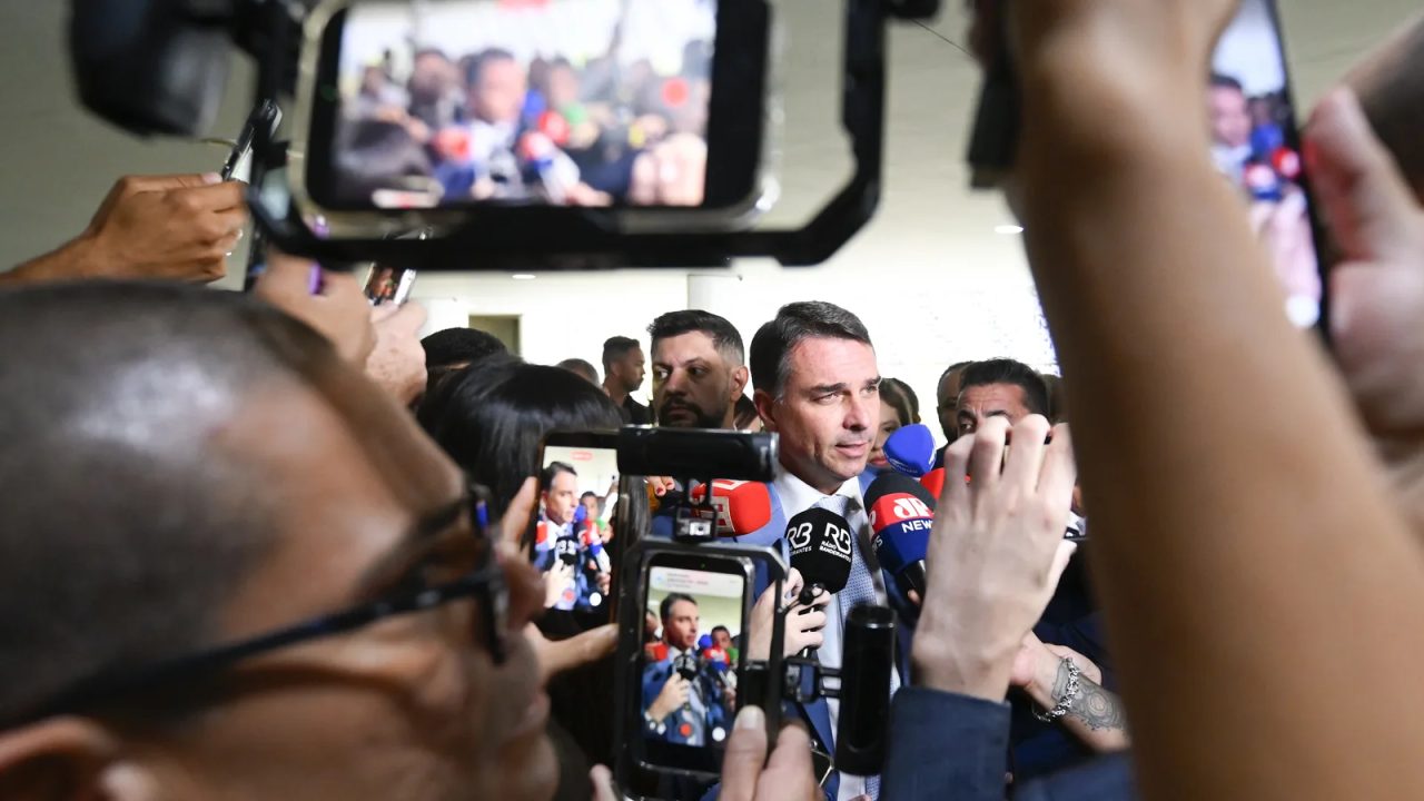 Flávio Bolsonaro em evento de campanha, apontando resultados da pesquisa Datafolha
