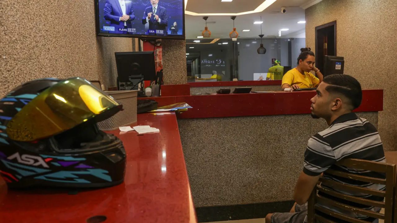 Candidatos Flávio Bolsonaro e Lula participando de debate televisivo