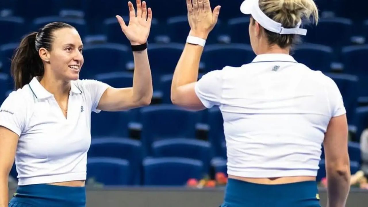 Luísa Stefani e Gabriela Dabrowski comemorando vitória em quadra de tênis em Pequim