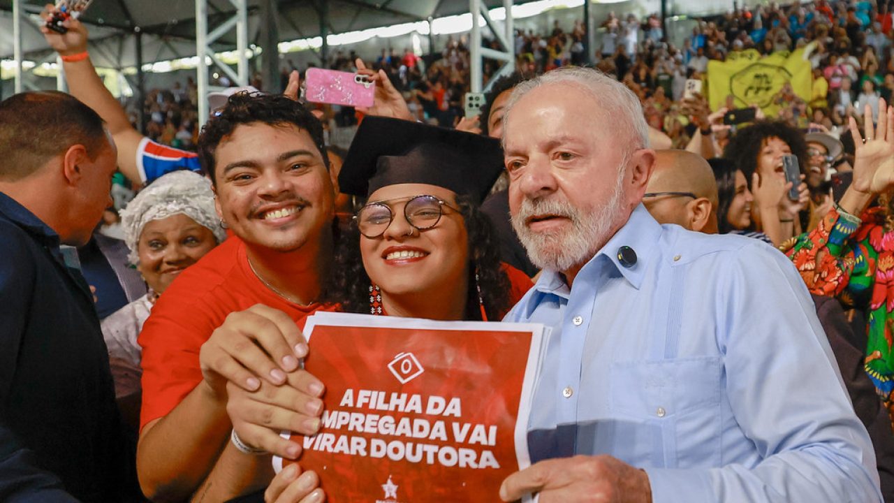 Apoiadores do presidente Lula em ato ao ar livre no Largo da Batata, São Paulo, sob chuva