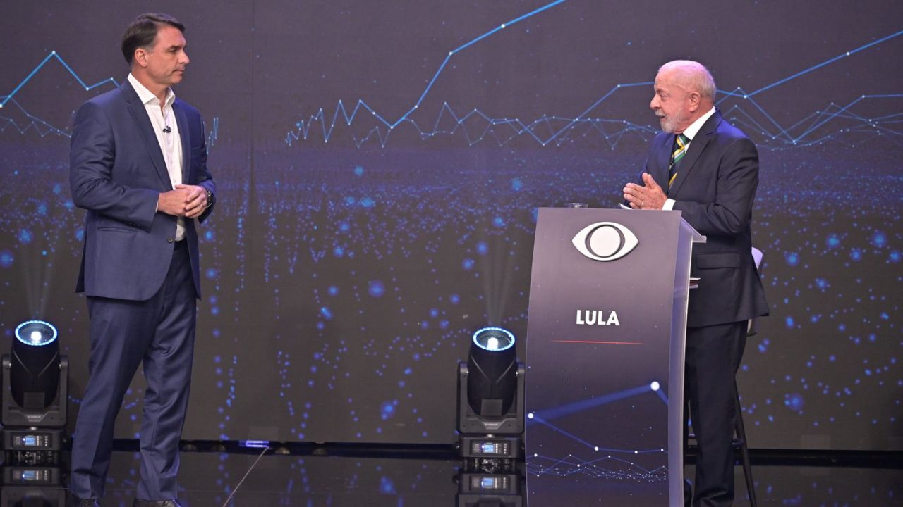 Lula e Flávio Bolsonaro trocando acusações durante debate na TV Band