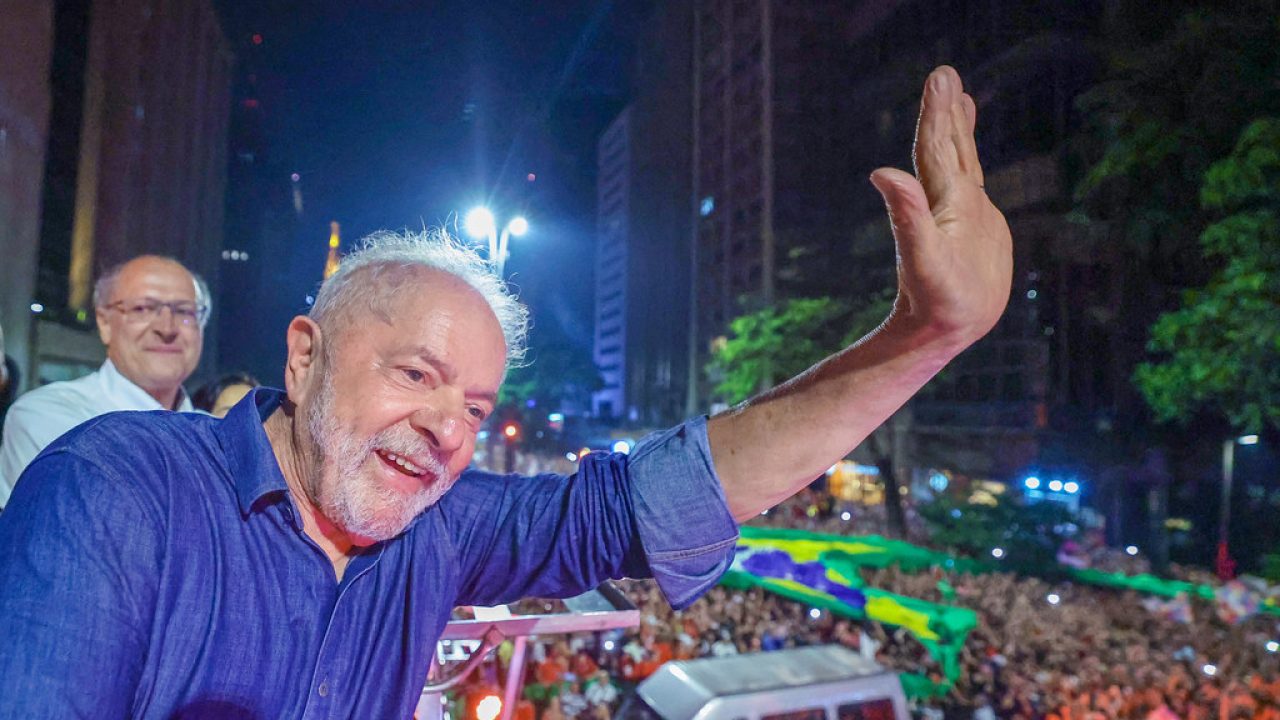 Lula discursando na Avenida Paulista durante a festa da vitória, com público ao fundo