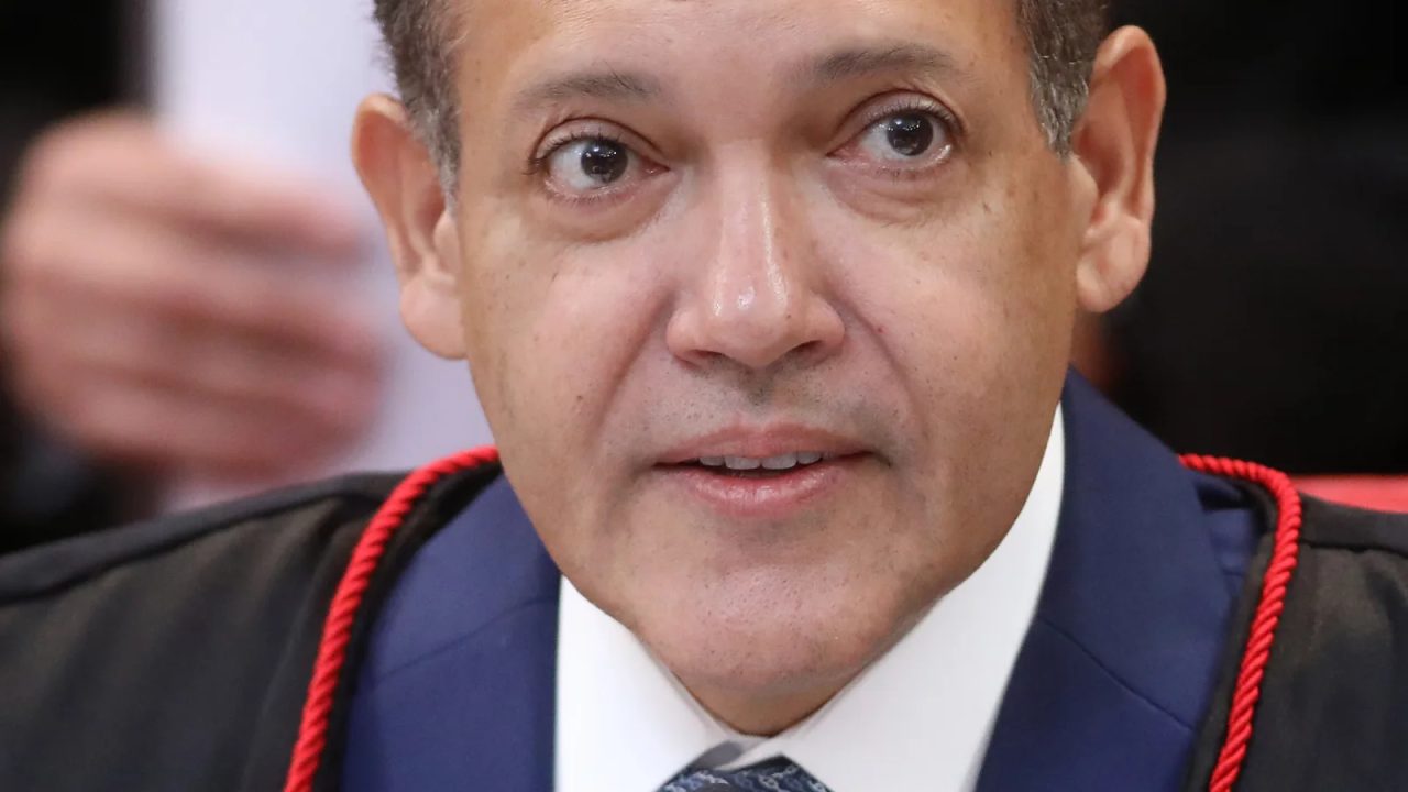 Ministro Kassio Nunes Marques assinando decisão sobre uso de veículos federais para transportar eleitores indígenas