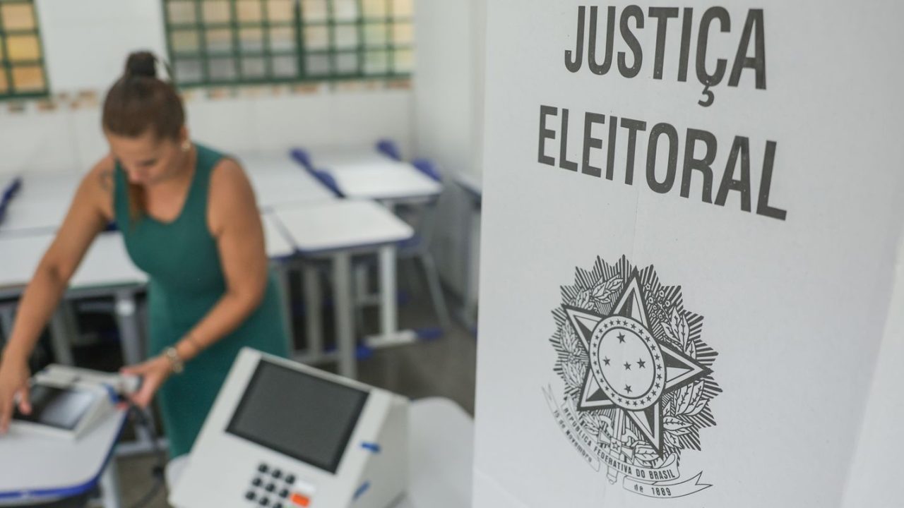 Eleitor entrando na cabine de votação com documentos