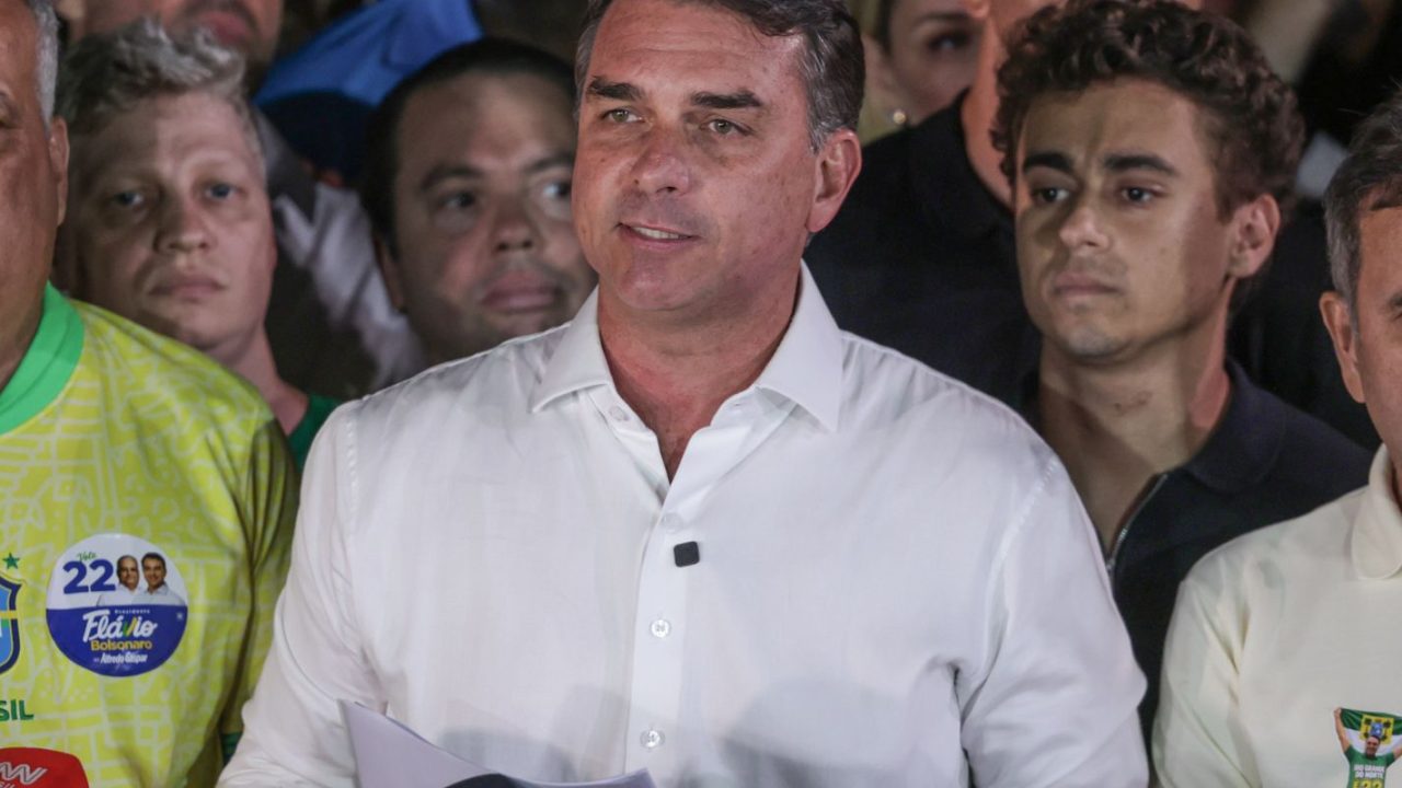 Passaporte brasileiro com selo de cancelamento nas mãos de autoridade