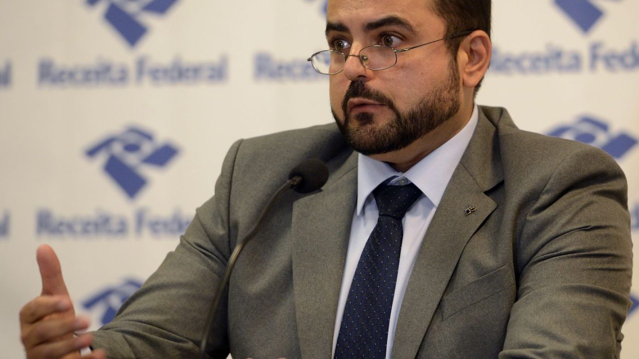 Auditor da Receita Federal analisando documentos de postos de combustível em Minas Gerais