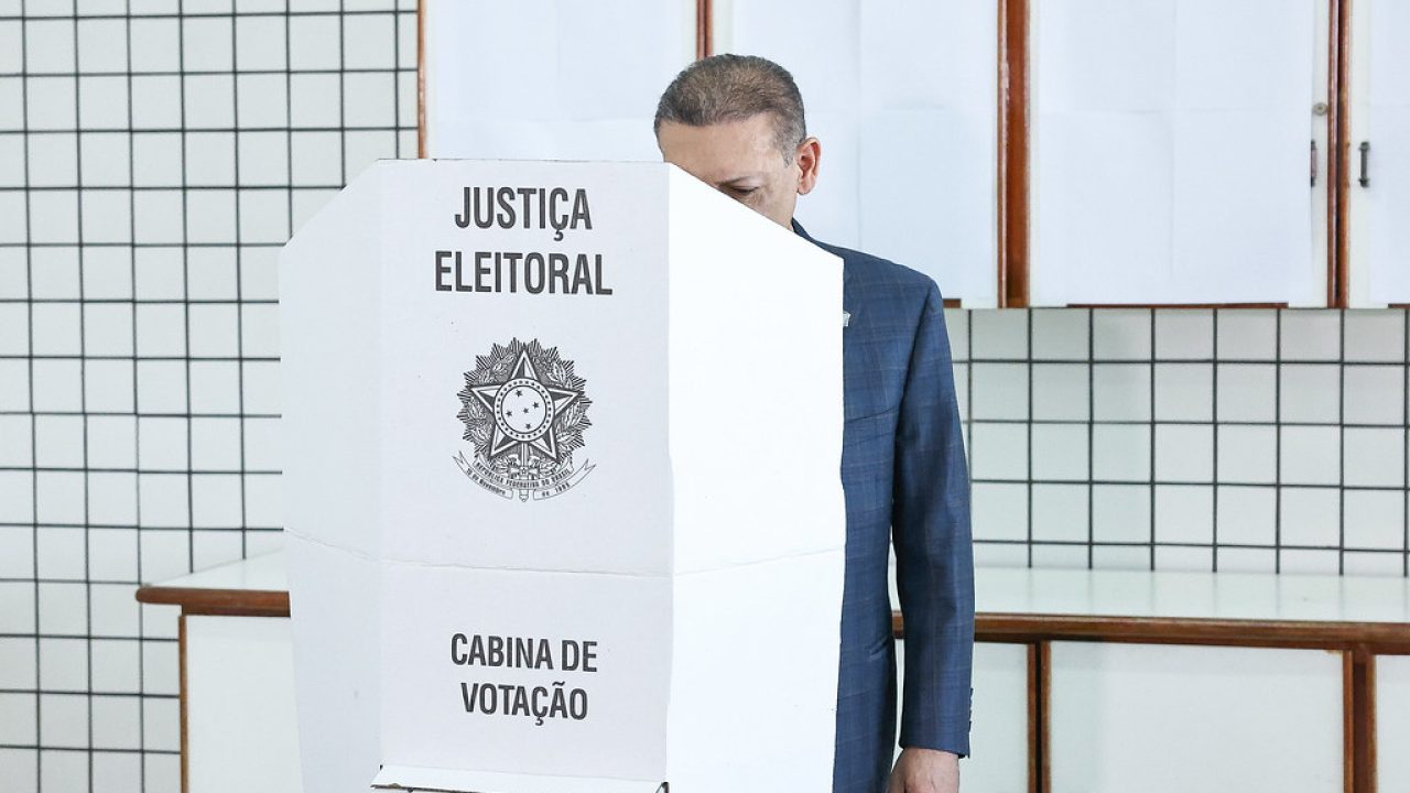 Placa de votação em frente a um local de votação em São Brás do Suaçuí