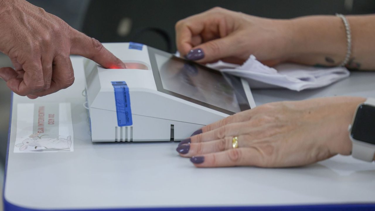 Urnas eletrônicas sendo fechadas em seção de votação no Distrito Federal